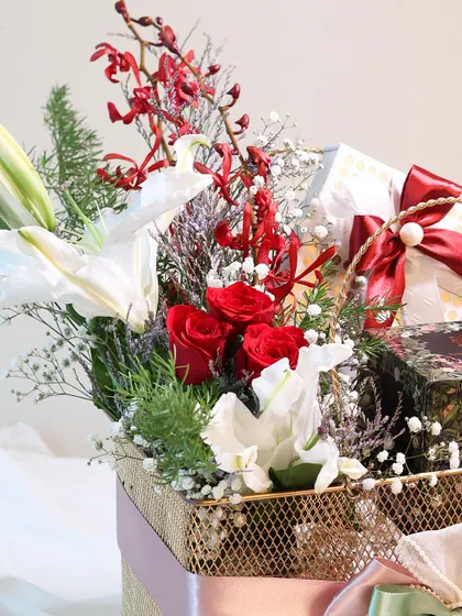 A detail shot of the fresh red roses and white lilies in the Mother's Day basket.