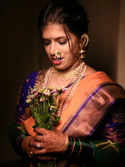 A beautiful, softly lit portrait of the bride holding a bouquet, looking down with a gentle smile.