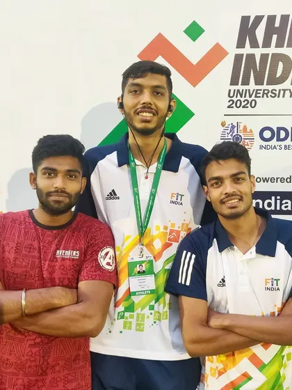 Posing with teammates in front of the Khelo India banner.