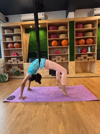 Combining the support of the aerial hammock with a mat-based backbend. This creative approach helps build strength and confidence for more advanced asanas.