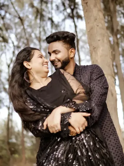 An embrace among the trees. The way the light filters through the forest canopy creates a magical effect, perfectly framing the couple's happy moment.