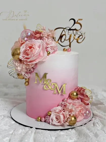 Our bestselling design this season. This pink ombre cake is decorated with a cascade of handcrafted pink flowers and gold accents, perfect for a 25th anniversary.