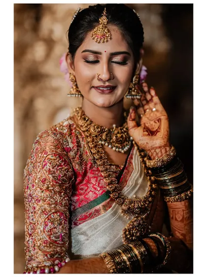 My beautiful client-turned-family, Chethana, looks timeless in this white and pink Kanchipuram saree. I designed a heavily handcrafted bridal blouse with intricate zardozi work to complement the saree's elegance for her special day.