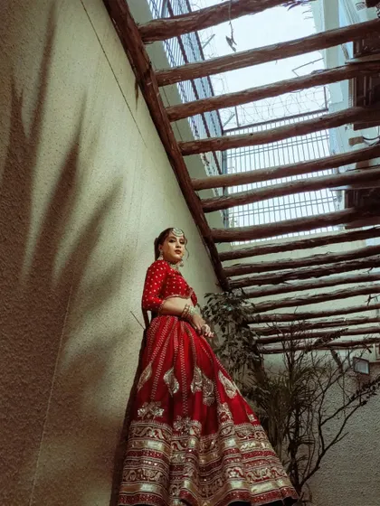 A full-length shot capturing the bride's pose, highlighting the intricate animal and floral motifs on the lehenga.