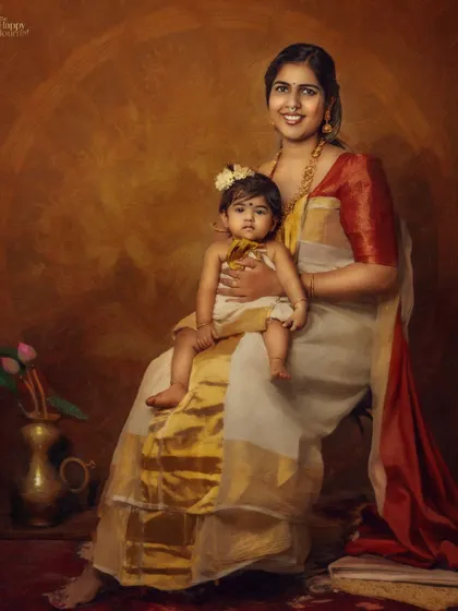 A fine art portrait of a mother and child in traditional Kerala attire. The painterly style and warm tones give this image a timeless, classic feel, like a piece of art.