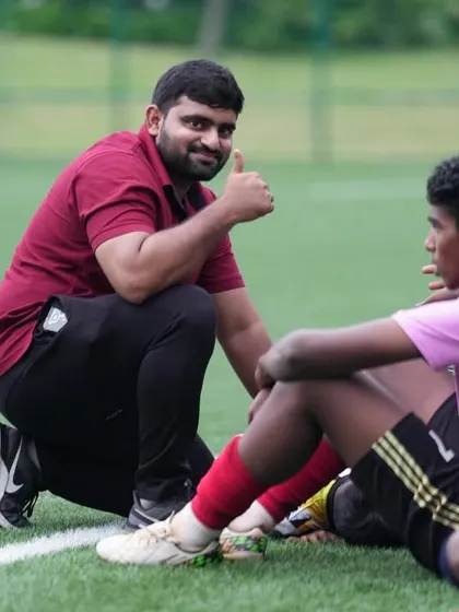 A physio giving a player encouragement and advice on the sidelines. This supportive environment helps players perform their best.