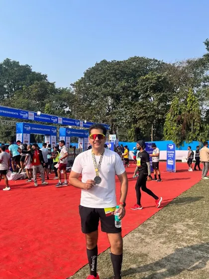 A runner proudly showing his medal after achieving a negative split at the Tata Steel 25k. Executing a race plan perfectly is a huge victory.