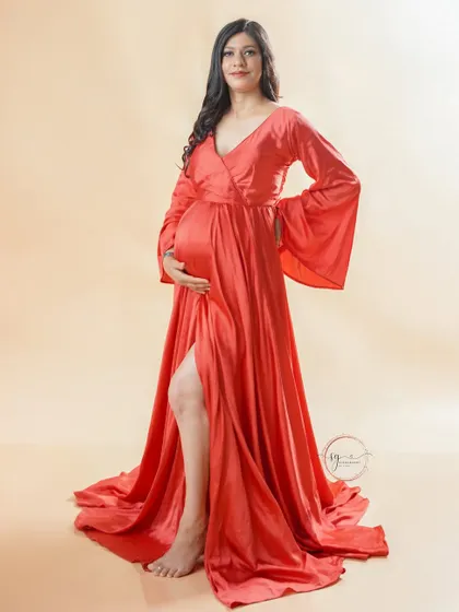 A confident and elegant pose from the mother-to-be. The side slit in the red gown adds a modern touch to this classic maternity portrait.