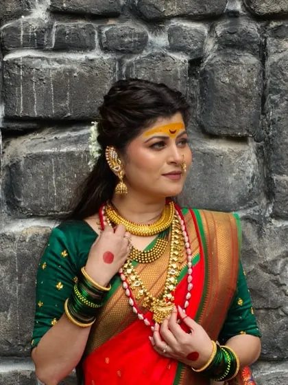 A profile shot capturing the details of the traditional jewelry and the intricate hairstyle. The makeup is designed to be dramatic and impactful for the video.