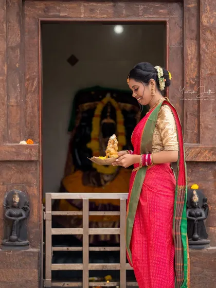 Seeking blessings at the temple. This full-length shot shows the complete traditional look, with makeup and hair styled perfectly for the occasion.