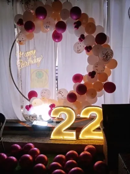 A simple yet elegant setup for a 22nd birthday, featuring a half-ring balloon arrangement and light-up numbers.