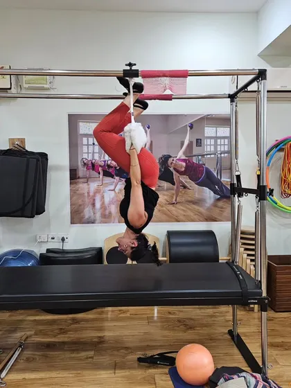 A different perspective of being upside down on the Cadillac. This move is a testament to the strength and control that Pilates builds.