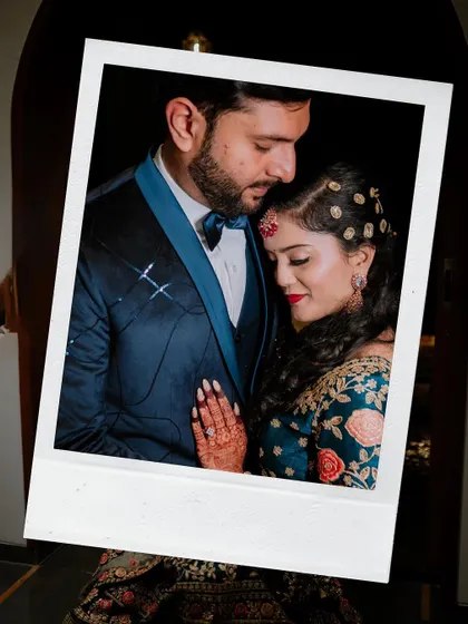 A close, romantic portrait of the couple, framed like a polaroid photo.