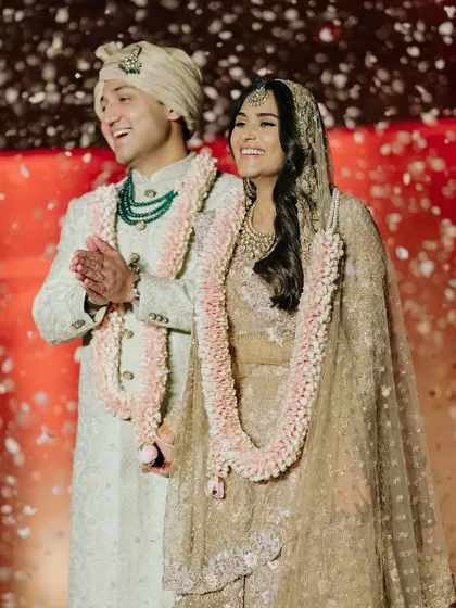 A candid moment of joy for the couple, framed by their stunning floral garlands. Our goal is to create a beautiful backdrop that allows the couple's happiness to be the main event.
