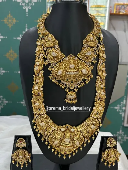 This grand bridal set features heavy carvings of Goddess Lakshmi, perfect for a traditional ceremony.