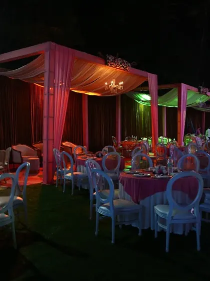 For this outdoor wedding, we created elegant canopies draped in soft pink fabric over each dining section. The mini chandeliers within each canopy added a touch of glamour and warmth to the evening.