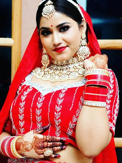 A gorgeous bride in her full wedding attire, with her mehndi adding to her beauty.