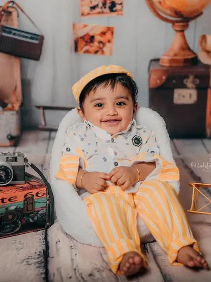 This little explorer is ready to see the world. The vintage travel props create a wonderful sense of nostalgia and adventure.
