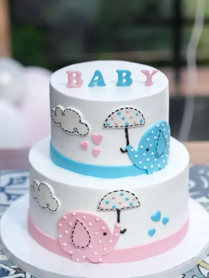 A client photo of our two-tier elephant baby shower cake. The pink and blue elephants are a sweet way to celebrate whether it's a boy or a girl.