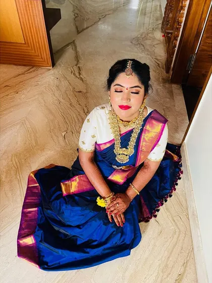 A moment of calm for the bride. The overhead shot showcases the beautiful eye makeup and the richness of her blue silk saree.
