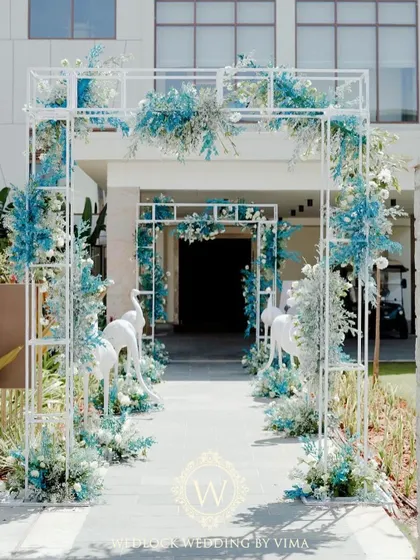 Welcome to paradise. For this brunch pool party, we designed a stunning floral archway flanked by white flamingo statues to set a chic, tropical tone right from the entrance.