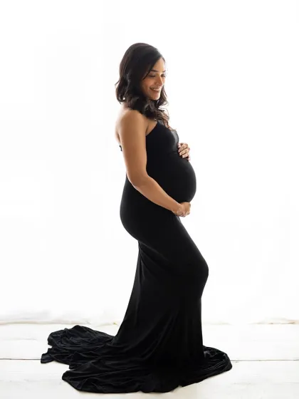 A smiling portrait of the mom-to-be in her elegant black gown. The simplicity of the shot allows her joy and beauty to be the complete focus.