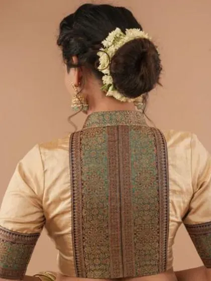 This high-collared blouse features a beautiful brocade back panel. The rich texture and elegant design make it a sophisticated choice.