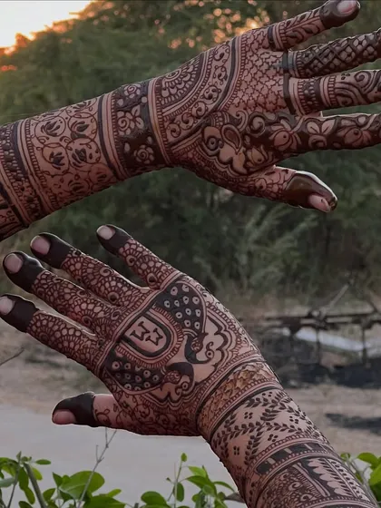 A detailed bridal design captured outdoors at sunset, with the warm light enhancing the henna's rich tones.