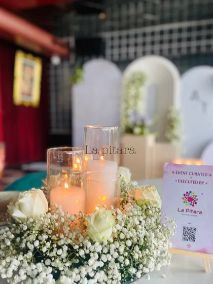 The table centerpieces consisted of pillar candles in glass hurricanes, surrounded by a bed of delicate baby's breath and white roses. This created a warm, romantic glow throughout the venue.