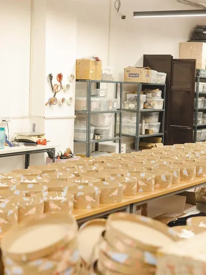 An assembly line of round gift boxes being prepared for a large Diwali order. This shows the scale and organization required during our busiest time.