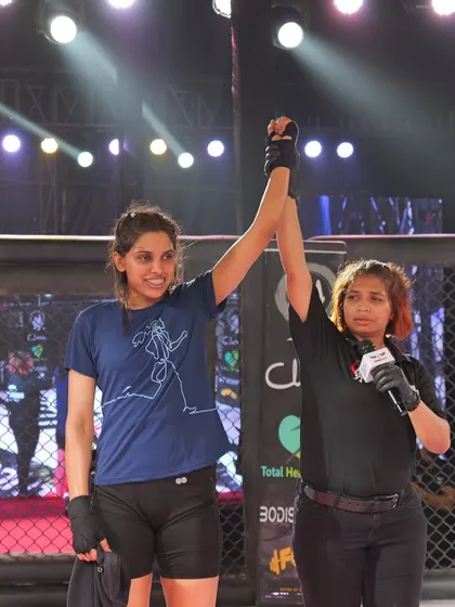 The referee raises Kiran's hand in victory after a skilled performance at ACS 9.