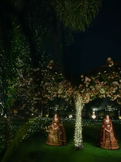 A magical nighttime bridal portrait, with the bride standing between two beautifully lit trees.