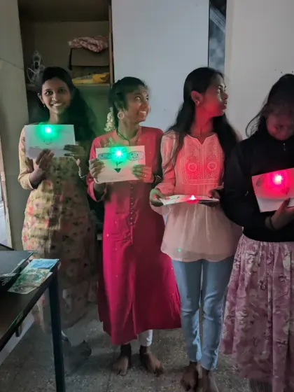 The joy of a successful experiment! Students showing off their finished light-up paper circuit cards. It's a simple yet powerful way to learn about series and parallel circuits.