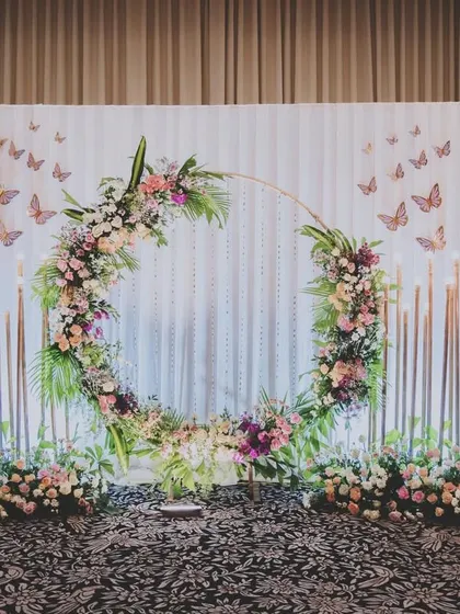 I believe in creating elegant and timeless setups for life's biggest moments. This engagement backdrop features a stunning floral ring against a delicate sequin wall, flanked by dramatic flower stands for a truly romantic photo corner.