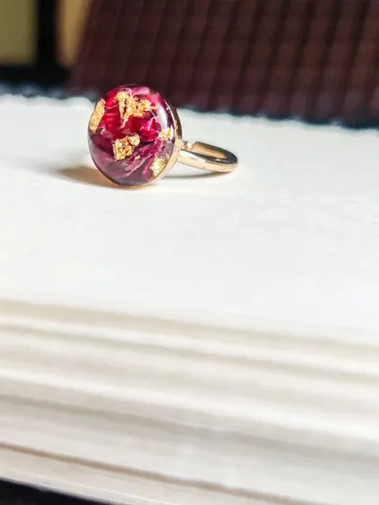 A simple yet stunning ring, featuring a real rose petal preserved in resin and accented with gold leaf. It's a delicate and personal piece of memory jewelry.