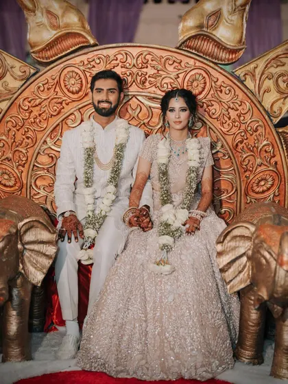 A royal portrait of the engaged couple. The bride's makeup is elegant and understated, perfectly complementing her ornate pastel lehenga.