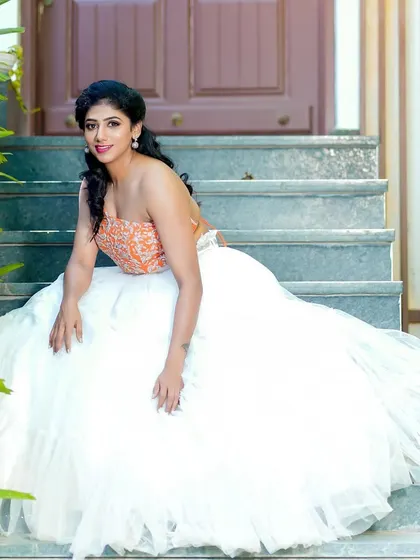 This full-length shot shows how the makeup and hairstyle work together with the flowing white skirt and modern crop top, creating a perfect fusion look for a pre-wedding shoot.