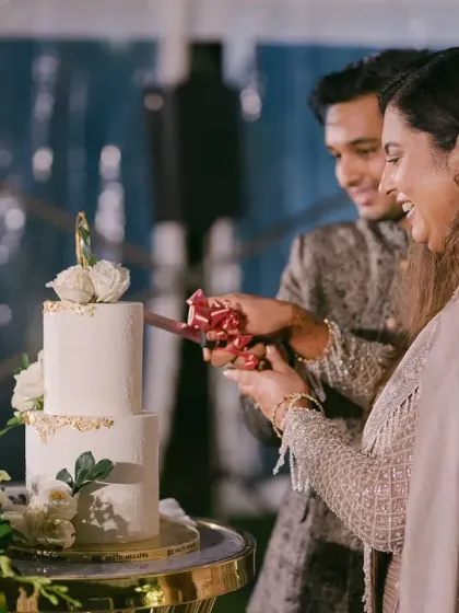 The cake cutting ceremony is a classic moment. We designed this elegant cake station with a minimalist white floral backdrop, ensuring the focus remained on the couple's happy celebration.
