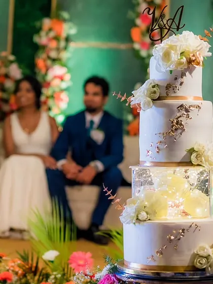The wedding cake as the perfect backdrop. This four-tier creation featured white sugar flowers, gold leaf details, and illuminated spacer tiers for a touch of glamour.