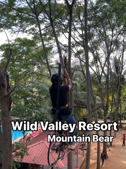 A guest navigates the sky cycling course at our Mountain Bear resort. This activity requires balance and courage as you pedal your way across a cable high above the ground.