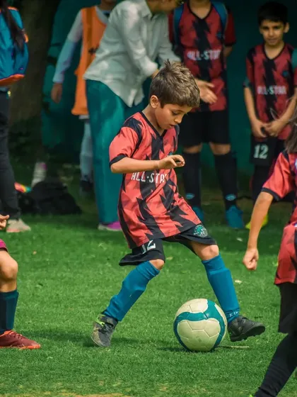A young player with great focus dribbles through the midfield.