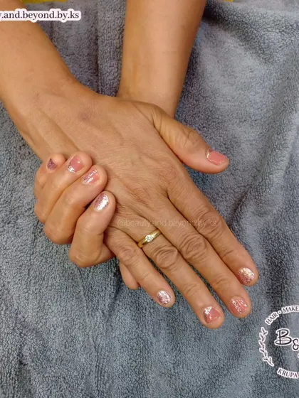 Another view of this delicate nude and glitter manicure, showing how a little sparkle can elevate a simple design.