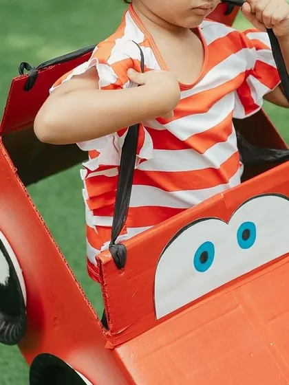 A little racer enjoying the custom-made cardboard car. These interactive props add a whole new level of play and imagination to our themed parties.