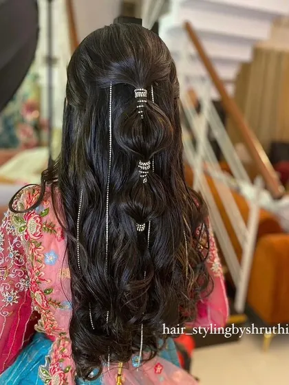 An intricate half-up style with bubble-like sections and hanging crystal chains. This is a very trendy and modern hairstyle, perfect for a sangeet or cocktail night.