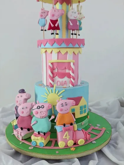 A different angle of the Peppa Pig cake, showing the whole family on a train at the base, ready to celebrate.