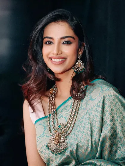 A beautiful portrait in a light teal silk saree, paired with a stunning multi-layered traditional necklace. This styling balances classic elegance with a soft, modern feel.