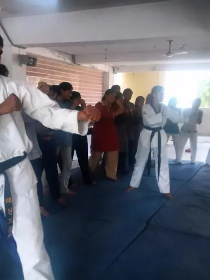 Leading a group of women in a self-defense workshop. We practice basic blocks and stances to build a strong foundation for personal safety.