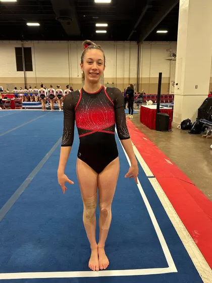 An Optional Team gymnast presents herself to the judges before her routine at the Metroplex Challenge.