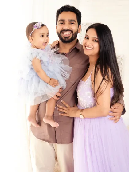 A classic, smiling family portrait against a clean, bright background.