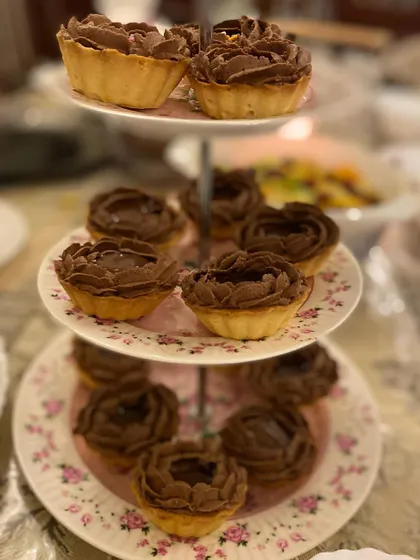 My divine chocolate tarts, with a rich chocolate filling piped into a beautiful rose shape, served on a three-tier stand.